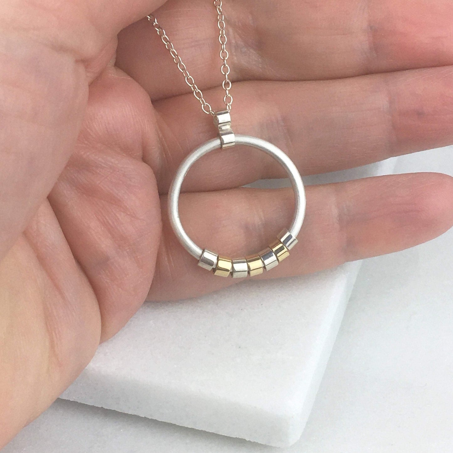 CIRCLE NECKLACE WITH SILVER AND GOLD MOVING PIECES - Genevieve Broughton